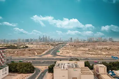 a view of a city with a highway and buildings at Cozy 1 BR with gym & pool just 15min to Dubai Marina in Dubai