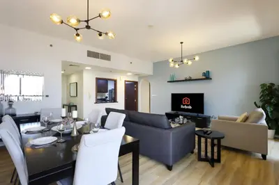 a living room with a dining table and a couch at Livbnb - Scenic 2BHK with Amazing Marina Views in Dubai