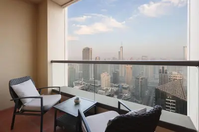 a balcony with two chairs and a table and a large window at Livbnb - Scenic 2BHK with Amazing Marina Views in Dubai