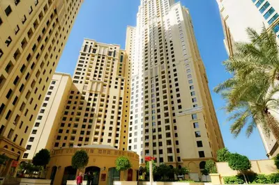 a group of tall buildings with palm trees in front at Livbnb - Scenic 2BHK with Amazing Marina Views in Dubai