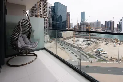 a chair sitting on a balcony with a view of a city at KeyRock Living - Zada 1BR with Pool & Gym Access in Dubai