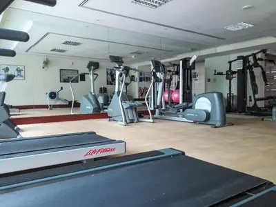 a gym with several treadmills and machines in it at Frank Porter - Lake Terrace Tower in Dubai