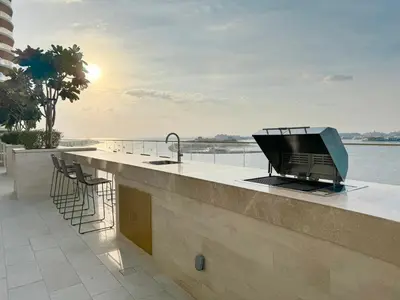 a kitchen with a counter with a television on it at Coastal Elegance 1-Bedroom in Grand Bleu in Dubai