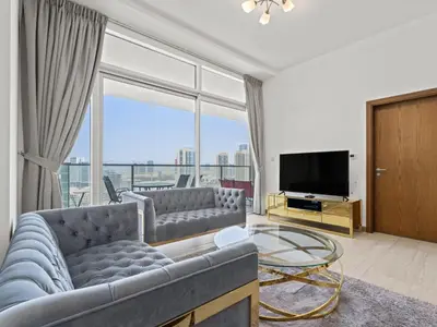 a living room with a couch and a television at Spacious and Cozy 1BDR in Hameni in Dubai