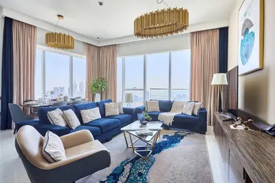 a living room with a blue couch and a tv at Frank Porter - Palm View in Dubai