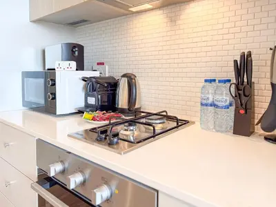 a kitchen counter with a stove and a microwave at Modern Chic Studio Apartment, Belgravia Heights 2, JVC Dubai in Dubai