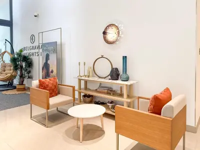 a living room with two chairs and a table at Modern Chic Studio Apartment, Belgravia Heights 2, JVC Dubai in Dubai