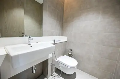 a bathroom with a white sink and a toilet at Stunning 1 Bdr Luxury District one in Dubai