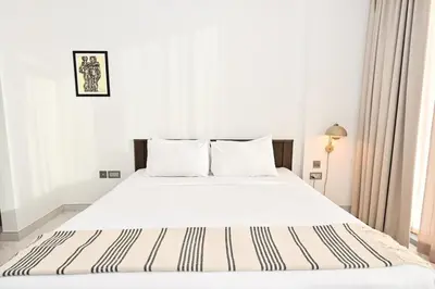 a white bedroom with a bed with white sheets and pillows at Stunning 1 Bdr Luxury District one in Dubai