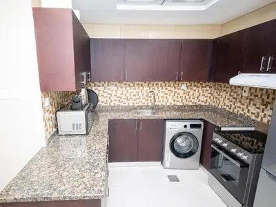 a kitchen with a sink and a washing machine at Court Tower in Dubai