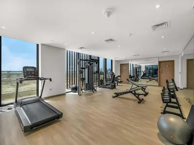 a gym with treadmills and exercise equipment in a building at Stylish Azizi 1 Bedroom in Dubai