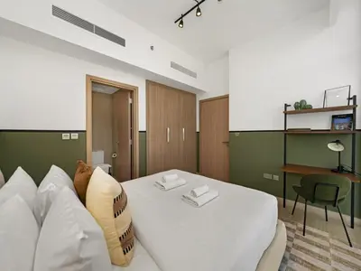 a living room with a white couch and a table at Stylish Azizi 1 Bedroom in Dubai