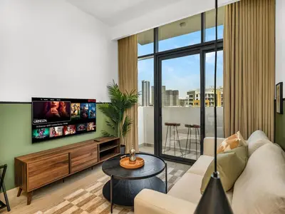 a living room with a couch and a flat screen tv at Stylish Azizi 1 Bedroom in Dubai