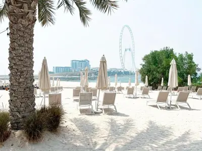 a group of chairs and umbrellas on a beach at Private Beach Access - Canal View in Dubai