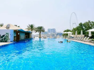 a large blue swimming pool with people in the water at Private Beach Access - Canal View in Dubai