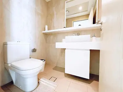 a bathroom with a white toilet and a sink at Private Beach Access - Canal View in Dubai