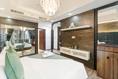a bedroom with a large white bed and a mirror at 2BR in Downtown with Burj Khalifa & Fountain views in Dubai