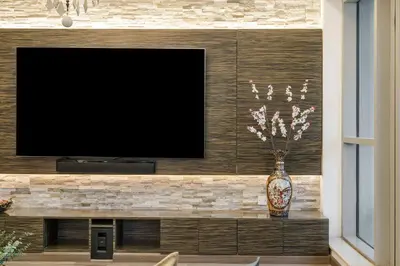 a flat screen tv on a wall with a vase at 2BR in Downtown with Burj Khalifa & Fountain views in Dubai