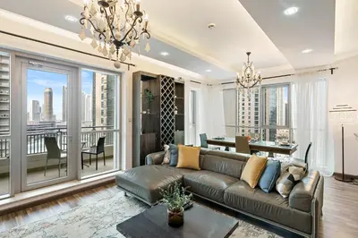 a living room with a couch and a large window at 2BR in Downtown with Burj Khalifa & Fountain views in Dubai
