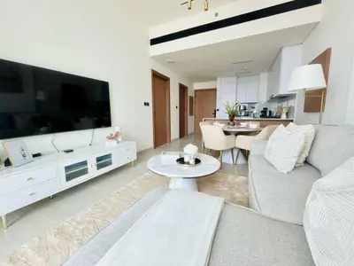 a living room with a couch and a large tv at Stylish 1br In Jvc Balcony, Pool & Free Parking in Dubai