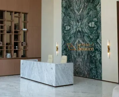a lobby with two chairs and a sign on a wall at Stylish 1br In Jvc Balcony, Pool & Free Parking in Dubai