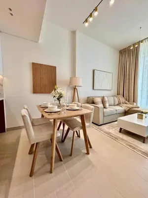 a living room with a table and a couch at Jvc 1br Oasis Serene Interiors Pool & Parking in Dubai