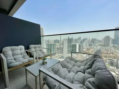 a living room with a large couch on a balcony at Bright 1br Jvc Balcony & Free Parking in Dubai