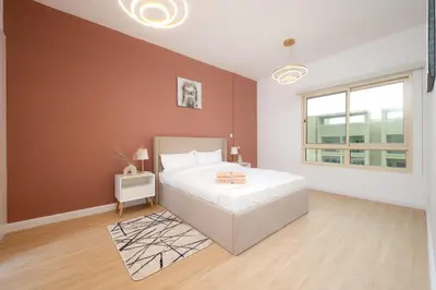a bedroom with a large white bed and a window at Serene Getaway in Dubai