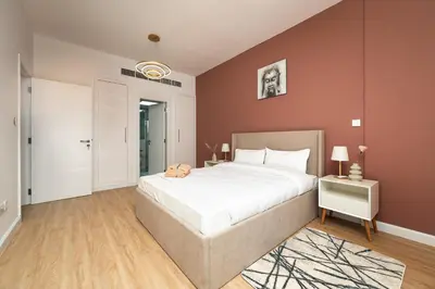a bedroom with a large white bed and a table at Serene Getaway in Dubai