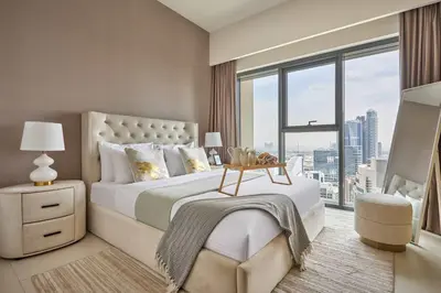 a bedroom with a large bed and a large window at Frank Porter - Burj Royale in Dubai