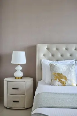 a white bed with a white lamp on a night stand at Frank Porter - Burj Royale in Dubai