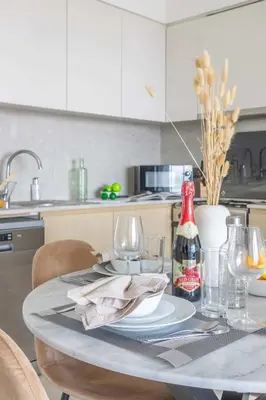 a kitchen with a table with a bottle of soda at Frank Porter - Burj Royale in Dubai