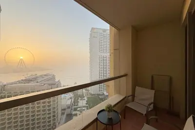 a room with a balcony with a view of the ocean at Luxe 2BR Dubai Retreat with Ain Dubai View for 6 guests in Dubai