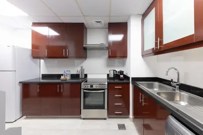 a kitchen with wooden cabinets and stainless steel appliances at Luxe 2BR Dubai Retreat with Ain Dubai View for 6 guests in Dubai
