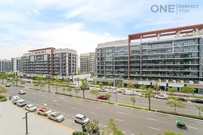 a city street with cars parked in front of buildings at Cozy Studio Apartment in Meydan in Dubai