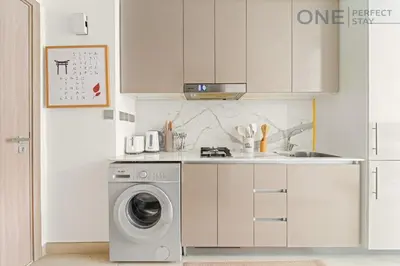 a kitchen with a washing machine and a sink at Cozy Studio Apartment in Meydan in Dubai