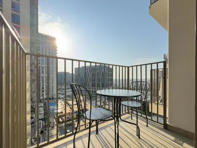 a balcony with a table and chairs and a view of a city at Cozy 1BR in Socio Dubai Hills Near Mall and Park in Dubai