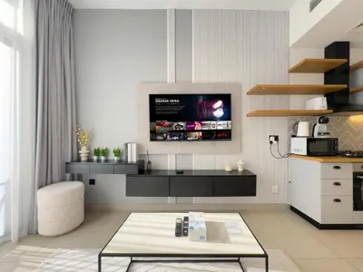 a kitchen with a tv on the wall at Cozy 1BR in Socio Dubai Hills Near Mall and Park in Dubai