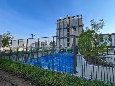 a fence with a pool in front of a building at Cozy 1BR in Socio Dubai Hills Near Mall and Park in Dubai