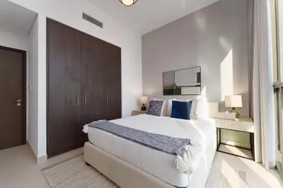 a bedroom with a large white bed with blue pillows at Elite Escape - 3 BHK Burj View & Dubai Mall Access in Dubai
