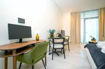 a room with a desk with a computer and a bed at High Floor Burj and Canal View Business Bay in Dubai
