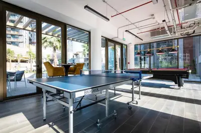 a ping pong table in a room with windows at High Floor Burj and Canal View Business Bay in Dubai