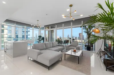 a living room with a couch and a tv at Full Sea View & Dubai Skyline - 4BR LUX Beachfront in Dubai
