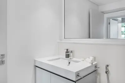 a white bathroom with a sink and a mirror at Full Sea View & Dubai Skyline - 4BR LUX Beachfront in Dubai