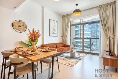 a living room with a table and a couch at Boho-Chic Comfort - 1BR Haven - Marquis 2020 Arjan in Dubai