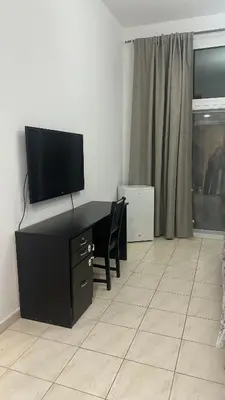 a living room with a desk with a flat screen tv at RKOkeys in Dubai