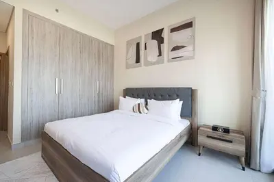a bedroom with a large bed with white sheets at Urban 1BR City view in The Bay Business Bay in Dubai