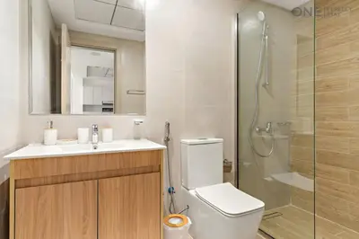 a bathroom with a toilet and a sink and a shower at 1BR with Balcony Near Metro Station in Dubai