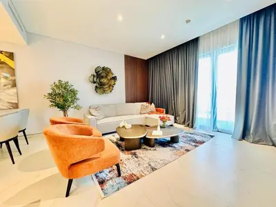 a living room with a couch and a table and chairs at Burj Khalifa View Modern 2BR CVG in Dubai