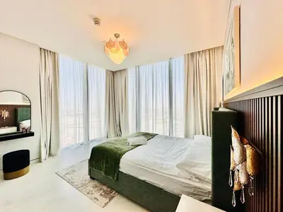a bedroom with a bed and a large window at Burj Khalifa View Modern 2BR CVG in Dubai